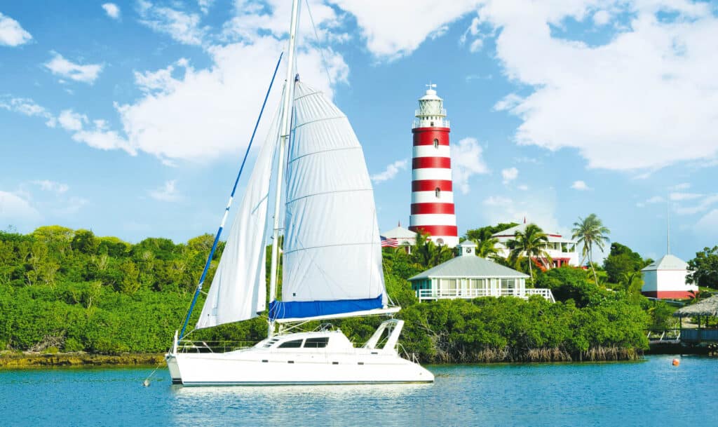 Catamaran devant le Phare de Hope Town, Abacos, Bahamas